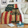 Disc golf throw blanket displayed on a sofa with basket and flying disc artwork