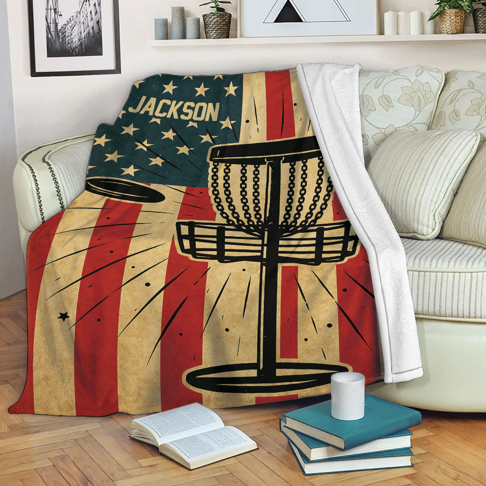 Disc golf throw blanket displayed on a sofa with basket and flying disc artwork
