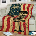 Disc golf blanket draped over a couch featuring a basket and flying disc design