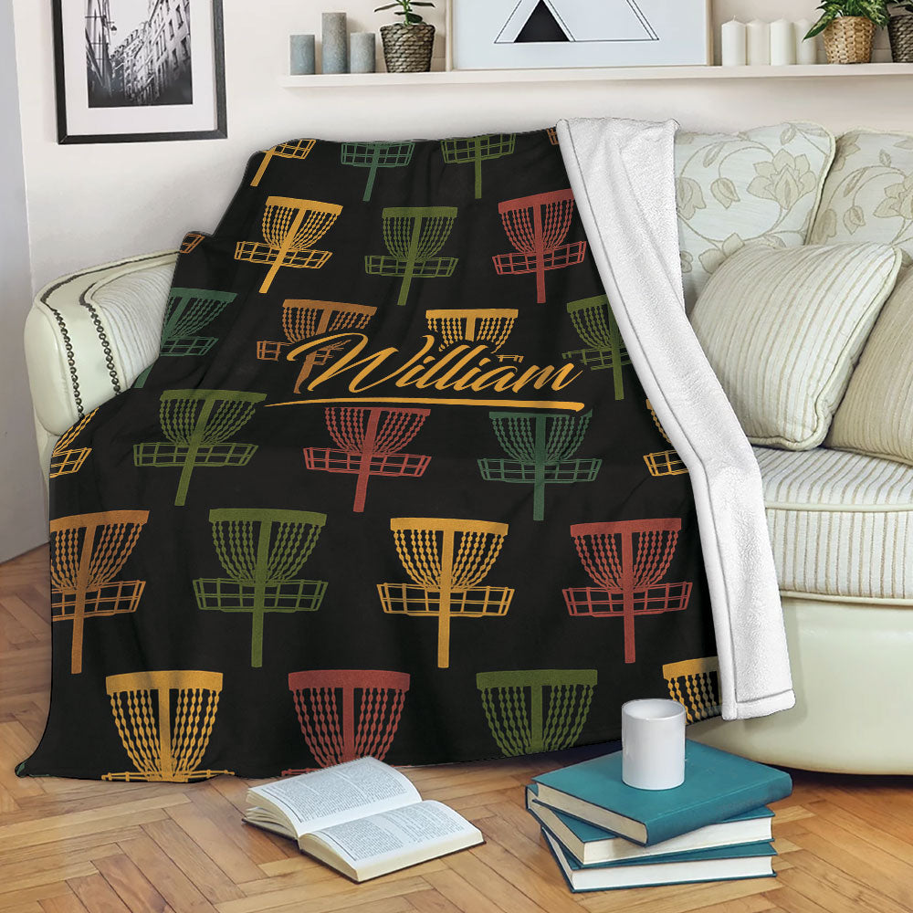 Disc golf blanket draped over a couch with colorful basket artwork and custom center design