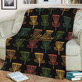 Disc golf throw blanket displayed on a sofa with multicolor basket graphics