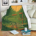 Disc golf throw blanket displayed on a sofa with forest scenery, a basket, and flying disc artwork