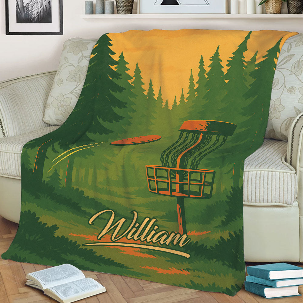 Disc golf blanket draped over a sofa with a wooded course, basket, and colorful flying disc design