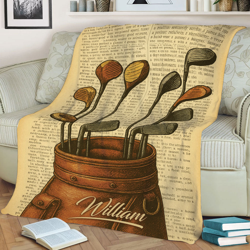 Vintage golf throw blanket displayed on a sofa with illustrated clubs, golf bag, and antique book-page background