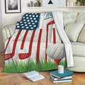 Patriotic golf throw blanket displayed on a sofa with golf clubs, ball, tee, and grass artwork