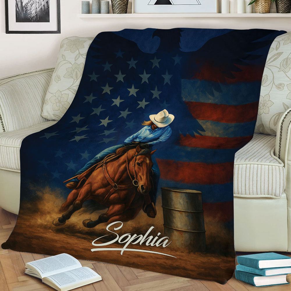 Patriotic barrel racing throw blanket displayed on a sofa with horse, rider, and barrel artwork