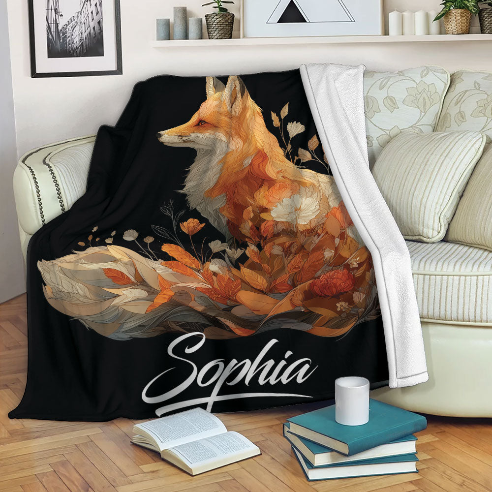 Fox throw blanket draped over a sofa, featuring orange botanical artwork on a black background