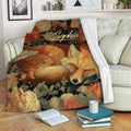 Floral fox throw blanket displayed across a sofa with warm woodland artwork and cozy living room styling