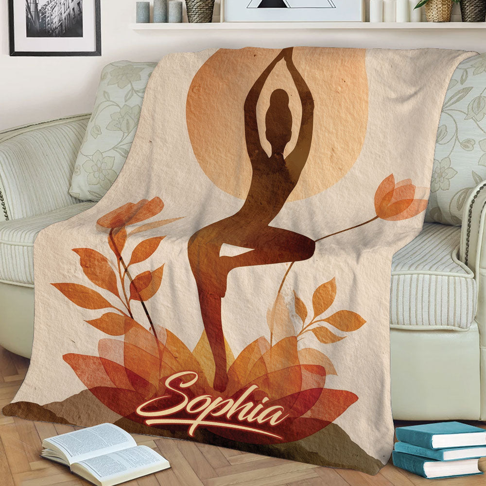 Close view of a yoga pose blanket with layered fall leaves and a rustic botanical design