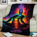 Cosmic chakra yoga blanket displayed on a sofa with a seated meditation figure