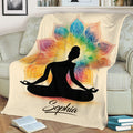 Yoga throw blanket draped over a couch, showing a meditating figure and multicolor mandala