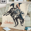 Rodeo throw blanket draped over a couch with bold bull riding and cowboy artwork