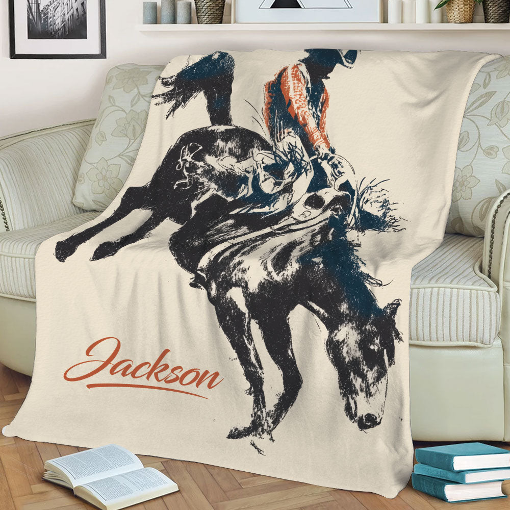 Rodeo throw blanket draped over a couch with bold bull riding and cowboy artwork