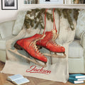Cozy sofa display of an ice skating blanket with red skates and evergreen branches