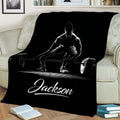 Close view of a black throw blanket with dramatic white weightlifting and barbell artwork