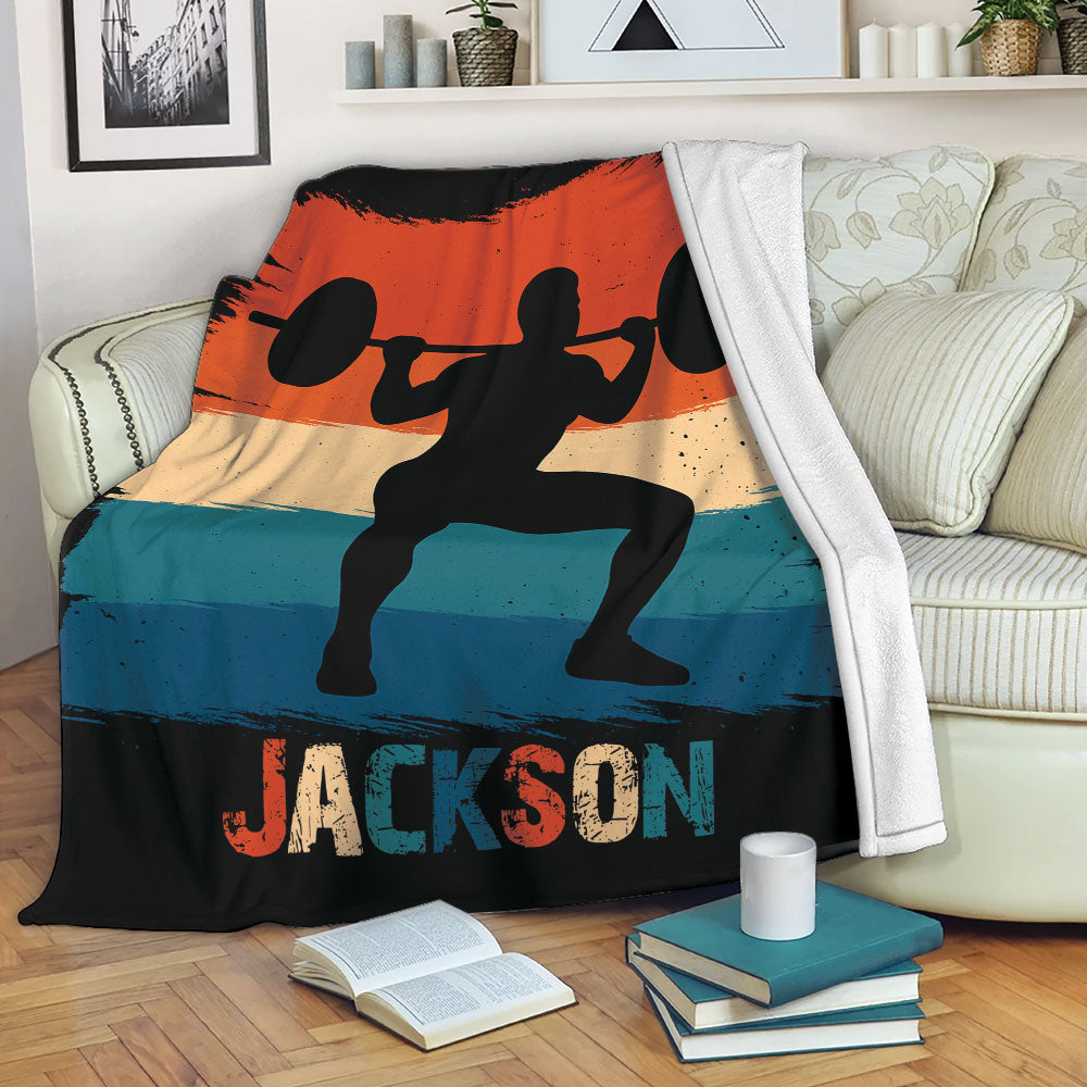 Weightlifting throw blanket draped over a sofa with barbell lifter artwork and bold distressed colors