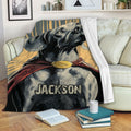 Weimaraner blanket draped across a cozy sofa, showcasing a dramatic dog illustration in warm gold and red tones