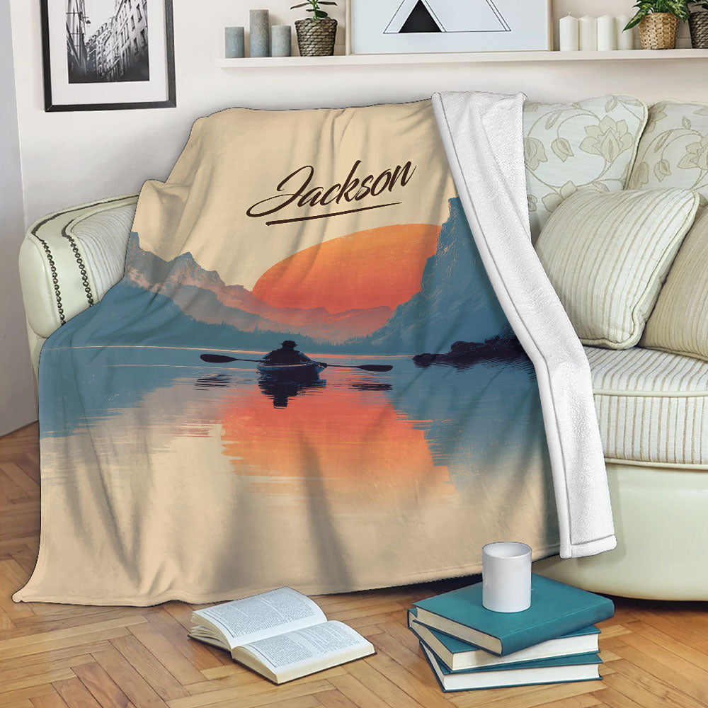 Kayak blanket draped over a sofa with a sunset mountain lake paddling scene