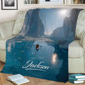 Blue kayak blanket displayed on a sofa with an icy canyon and sunlit water design