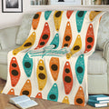 Kayak-themed throw blanket spread across a sofa with colorful paddling artwork