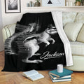 Black and white squirrel throw blanket displayed on a living room sofa with a soft white reverse