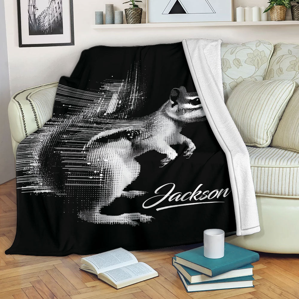Black and white squirrel throw blanket displayed on a living room sofa with a soft white reverse