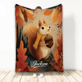 Autumn squirrel blanket design with an acorn, scarf, and colorful fall leaves