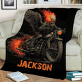 Motorcycle biker blanket draped over a couch with winged skull and flame artwork