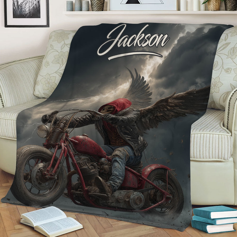 Biker throw blanket displayed on a couch with winged skull rider and red motorcycle design