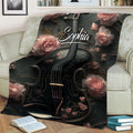 Decorative violin blanket featuring a black instrument, pink roses, and ornate floral details on a couch