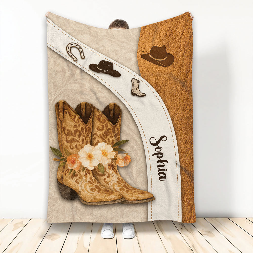 Cowgirl blanket displayed with floral Western boots, cowboy hats, horseshoe artwork, and rustic brown accents