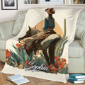 Close lifestyle view of a cowgirl on horseback surrounded by desert plants and vibrant flowers on a blanket