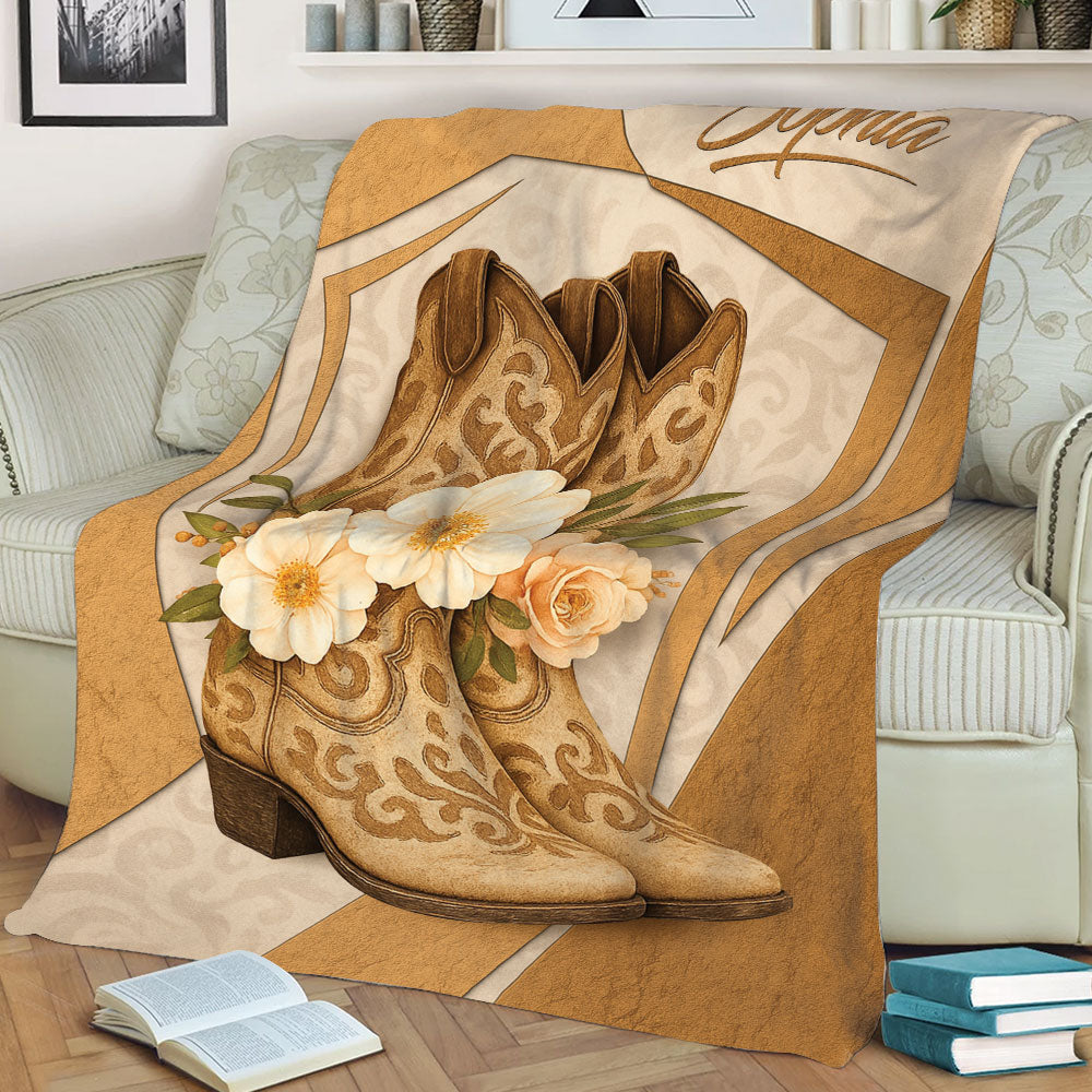 Rustic cowgirl throw blanket displayed on a sofa with ornate boots and cream flowers