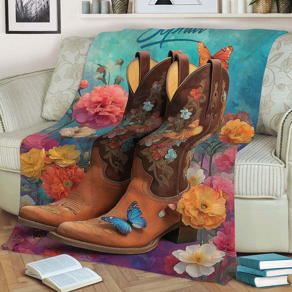 Cowgirl-inspired blanket displayed on a sofa with floral cowboy boots and vibrant botanical artwork