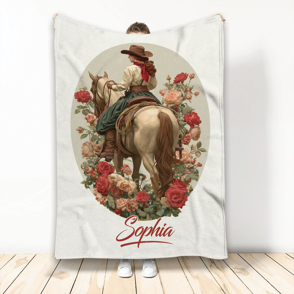 Cowgirl riding a horse among red and pink roses on a Western-themed throw blanket