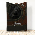 Black horse blanket displayed upright with brown and black saddle-inspired artwork