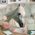 Close view of a floral horse throw blanket displaying a white horse portrait in a cozy living room setting