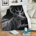 Black deer throw blanket displayed on a couch with striking monochrome wildlife artwork
