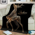 Black deer blanket draped across a sofa, showcasing detailed gold antler artwork