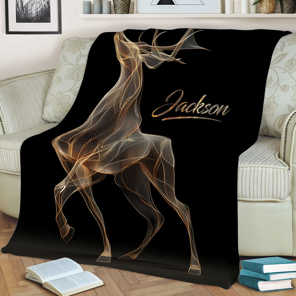 Black deer blanket draped across a sofa, showcasing detailed gold antler artwork