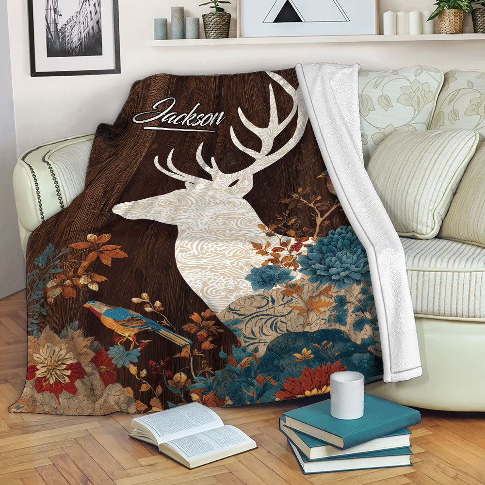 Rustic deer throw blanket displayed on a sofa with floral woodland artwork and a soft white reverse