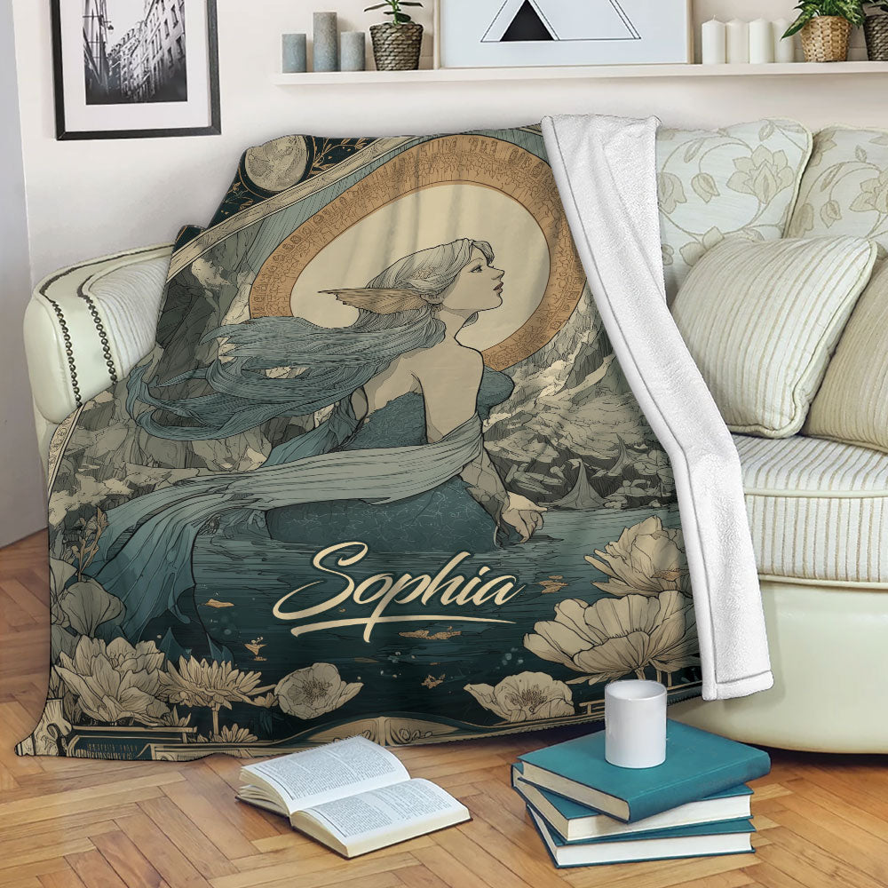 Mermaid blanket draped over a living room sofa with vintage-inspired aquatic artwork in muted teal and gold tones
