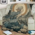 Close view of a mermaid throw blanket on a sofa featuring flowing hair, floral details, water, and a moonlit scene