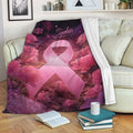 Breast cancer awareness throw blanket draped over a sofa with pink ribbon and floral artwork