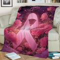 Pink ribbon breast cancer awareness blanket displayed across a sofa with floral design
