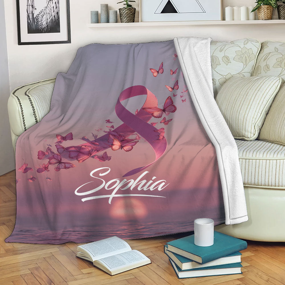 Breast Cancer awareness blanket displayed on a sofa with pink butterfly artwork