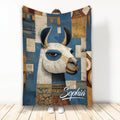 Alpaca throw blanket with a stylized animal illustration in blue, cream, ochre, and geometric patterns