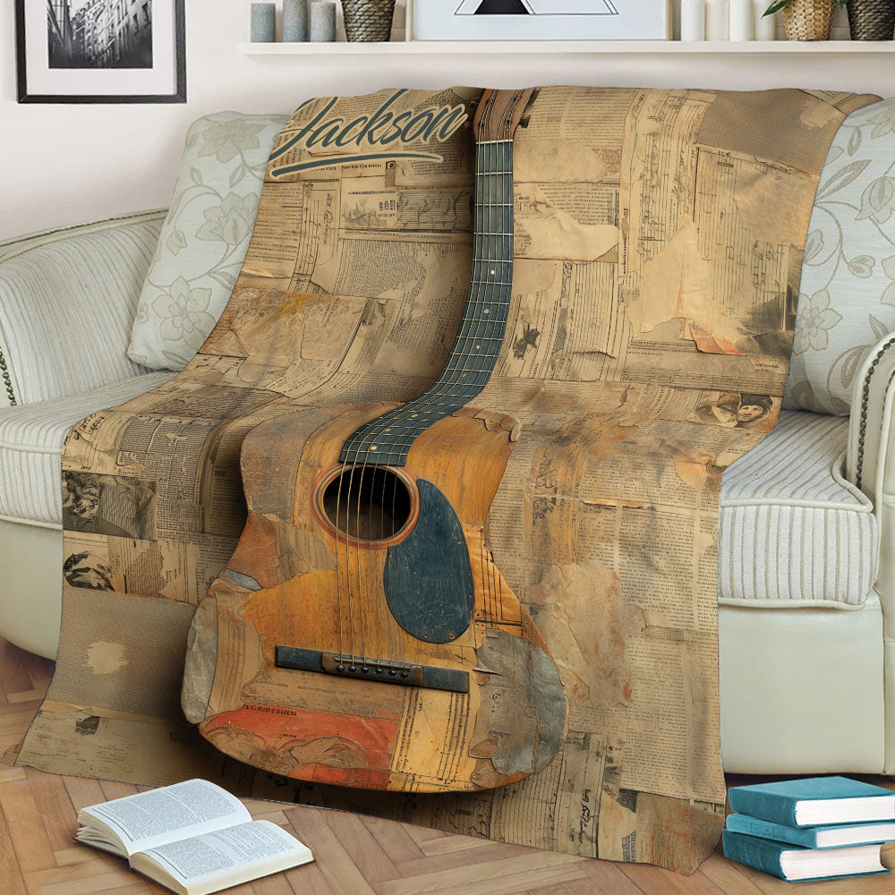 Rustic guitar throw blanket with newspaper collage artwork styled on a sofa