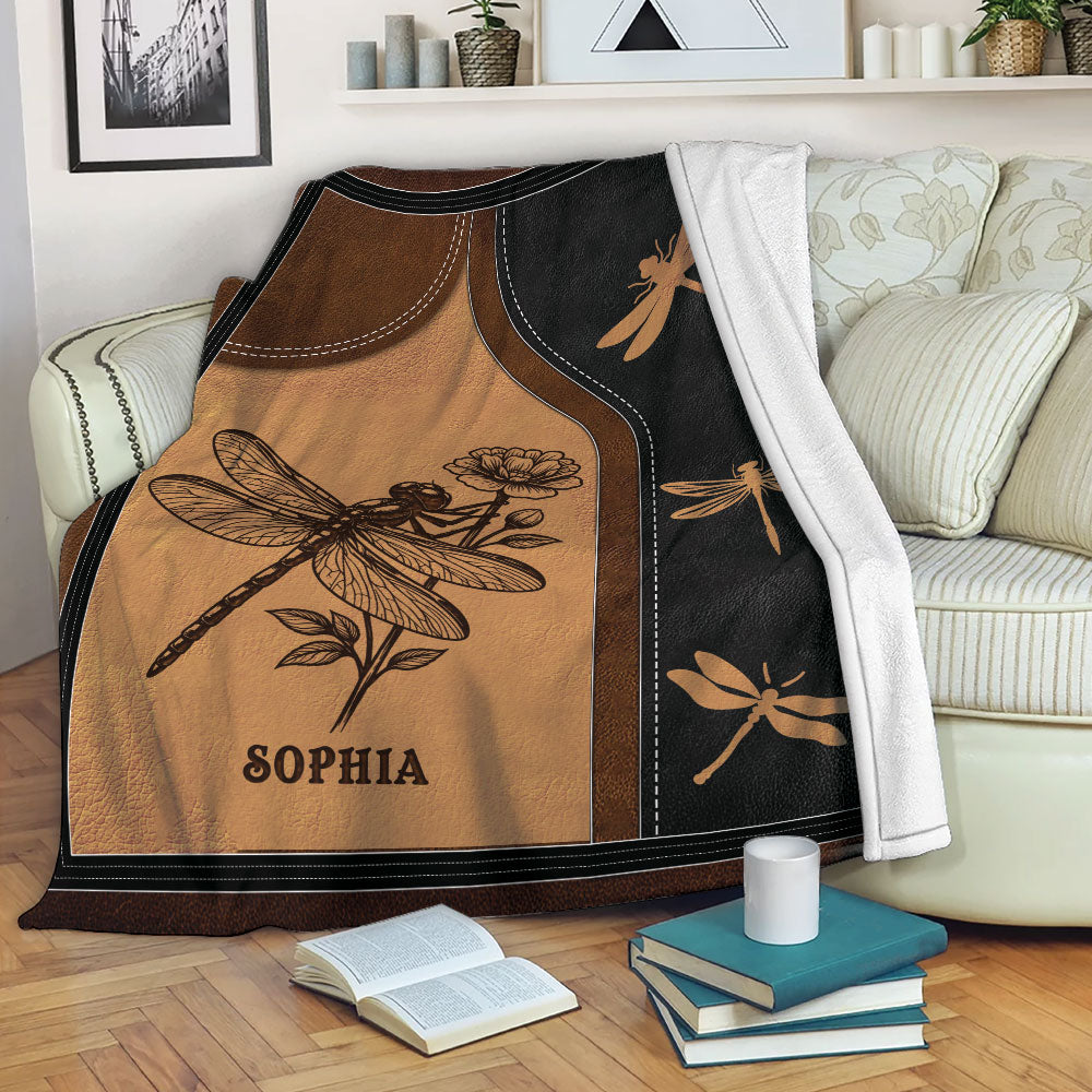 Dragonfly throw blanket displayed on a sofa with vintage brown and black nature artwork