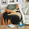 Black cat blanket draped over a sofa, featuring bold geometric shapes, a moon motif, and vintage-inspired colors